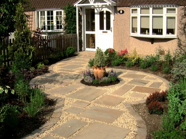 Small cottage style front garden with gravel and stepping stones