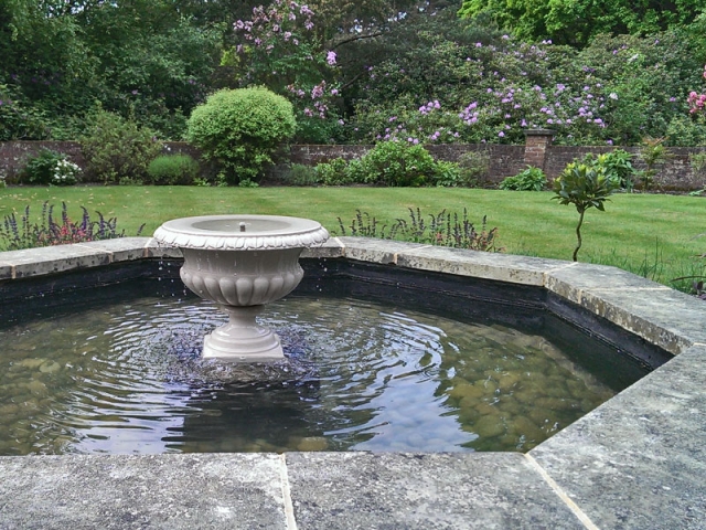 Traditional formal pool with central floating urn