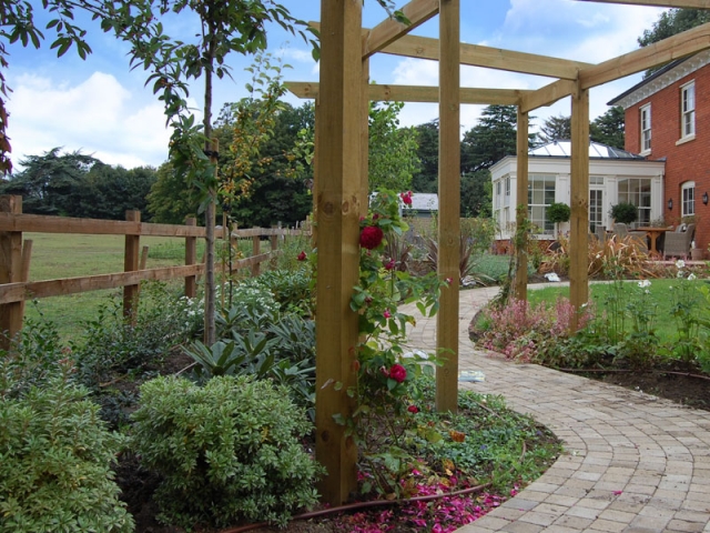 Pergola with roses and winding blockwork path