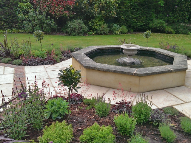 Octagonal formal pool with central floating urn and planting