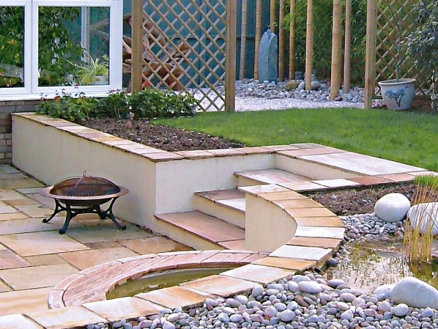 Sunken patio with cream rendered walls and water feature