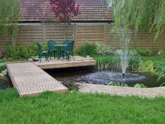 Medium pond with fountain and decking bridge and seating area