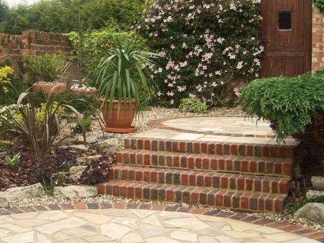 Brick steps and crazy paving with gravel surrounds and planting