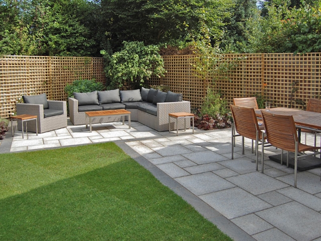 Outdoor lounge and dining areas with trellis boundary and granite paving