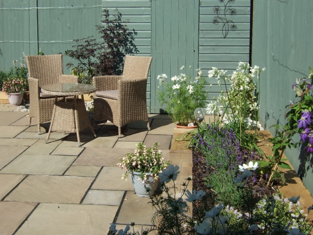 Contemporary small back garden with painted timber