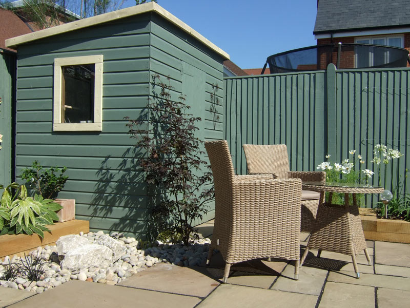 Contemporary small back garden with painted timber