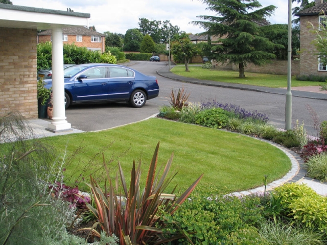 Neat lawn with edged with 2 rows of contrasting light and dark granite setts