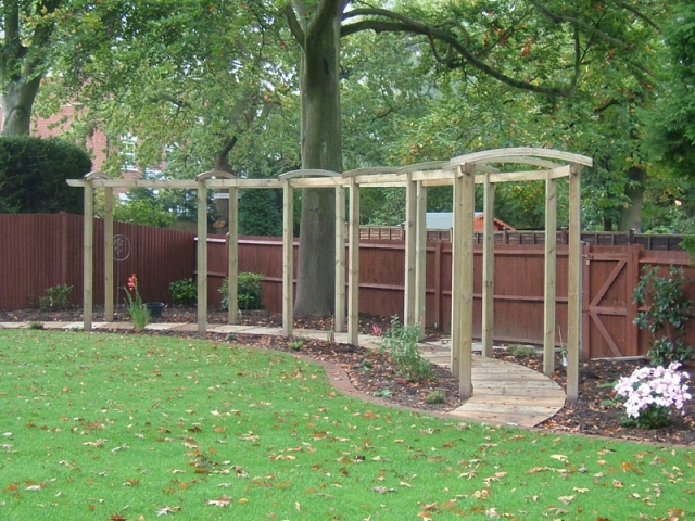 Long bow topped pergola over curving walkway