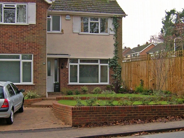 Curving brick terraces with steps to front door