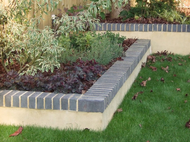 Low wall topped with blue engineering bricks